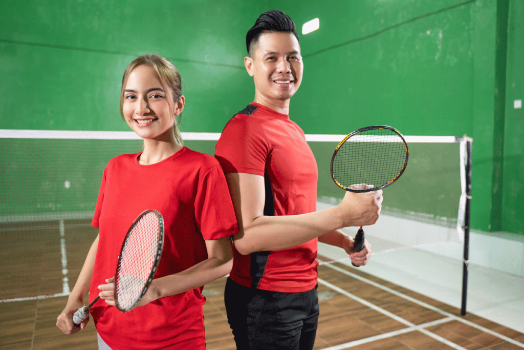 Suasana latihan komunitas badminton indoor dengan peserta dewasa yang sedang berlatih bersama pelatih.